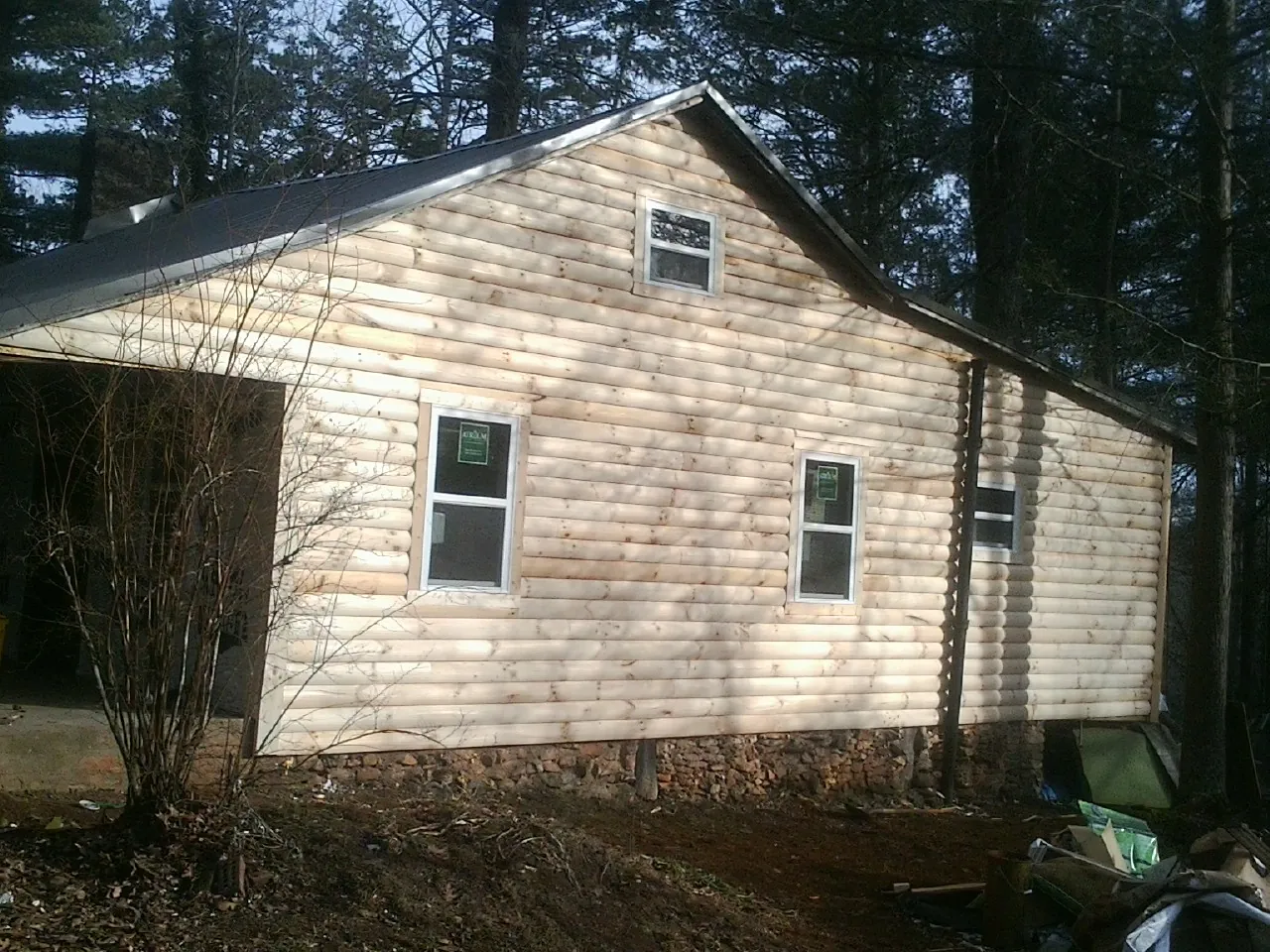 New log siding and dark metal roofing on a gable end in Anacortes