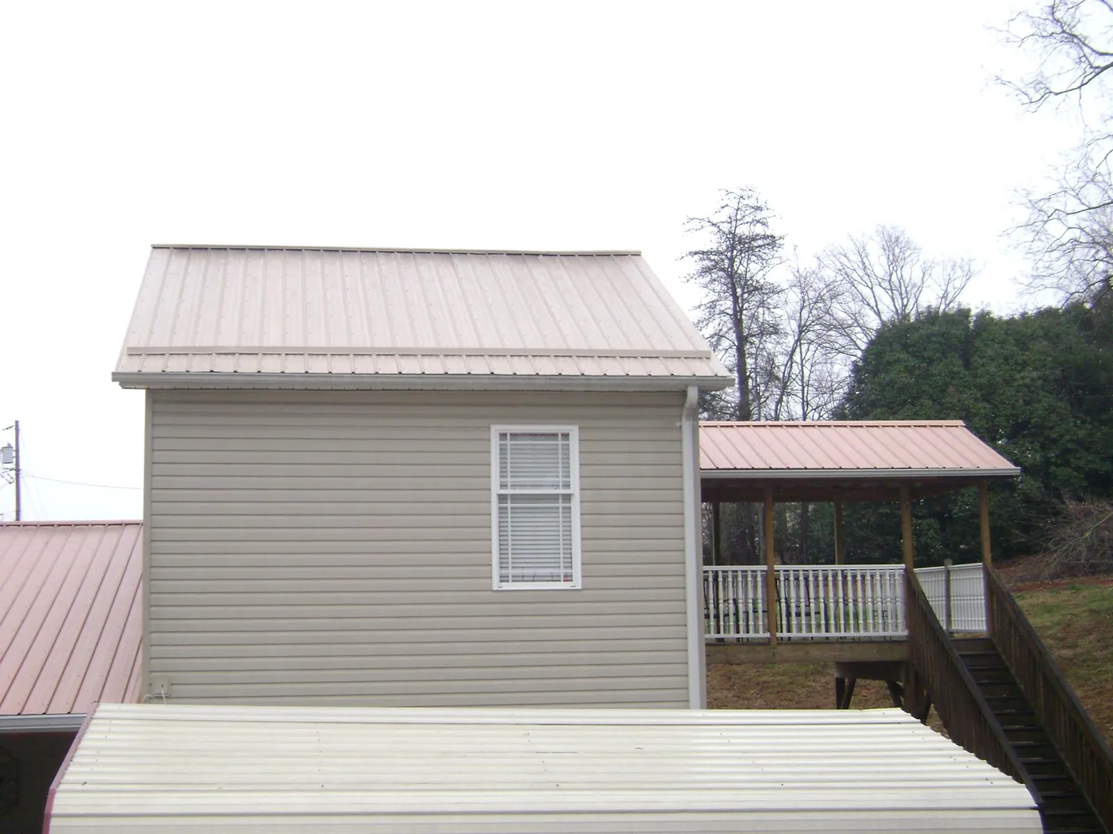 Tan metal roofs on a two story addition and attached porch, from a Roof Replacement job in Anacortes
